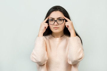 Emotional portrait of a dark-haired girl on a gray background, stormy emotions, business concept.	