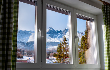 Beautiful  view through window at the Tatry mountains from the hotel in Tatrzanska Lomnica, Slovakia during winter season.