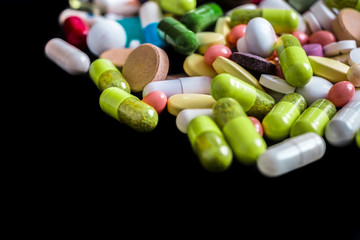 Pharmaceutical tablets, capsules, therapy drugs and pills on black background