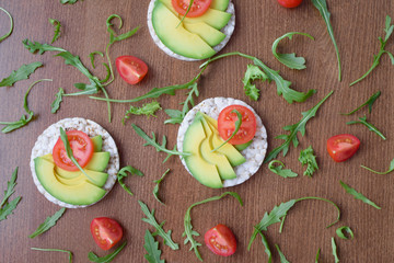 rice bread with avocado and tomato on wooden table