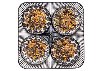 Bird seeds. Close-up of a decorative plate with four bowls with black sunflower seeds and other seed and nuts for feeding wild birds. Animal Welfare, Rescue and care. Macro. Top view.