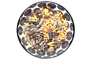 Bird seeds. Close-up of a decorative bowl with black sunflower seeds and other seed and nuts for feeding wild birds. Animal Welfare, Rescue and care. Macro. Top view.