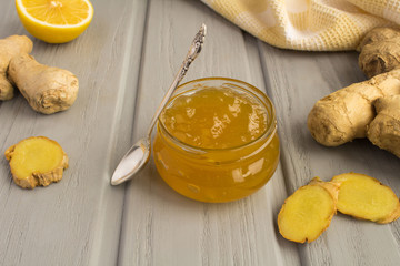 Ginger jam in the glass jar on the grey wooden background