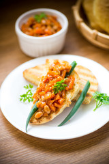 fried bread toasts with stewed beans and vegetables in a plate