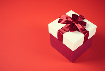 Beautiful present box on red background.