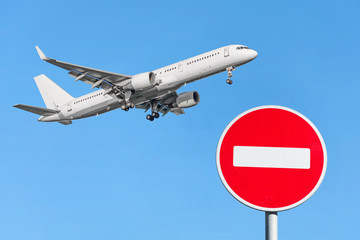 Red brick stop sign and an airplane flying in the sky. Flight Ban Concept