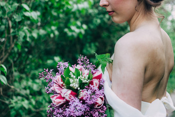 Fototapeta premium Elegant wedding bouquet in the hands of the bride. bouquet with lilac, white, pink roses. wedding bouquet
