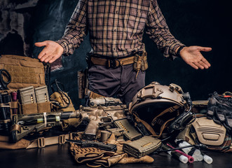 Man in a checkered shirt showing his military uniform and equipment. Modern special forces...