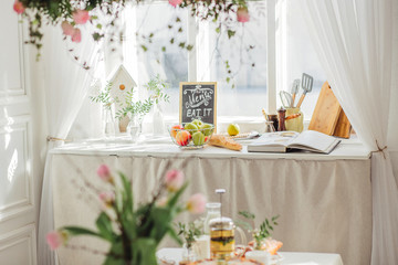 Spring flowers on light kitchen. Sunny day