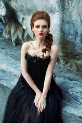 Art work Gothic fashion: a beautiful young girl in black dress and headwear sitting near castle....