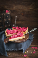 Homemade strawberry tart sliced on wooden plate on the rustic background