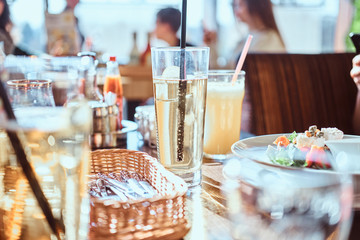 Young friends dine in the cafe outdoors. Close-up image of a table with different dishes and drinks