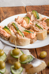 fresh small different canapes on plates with snacks