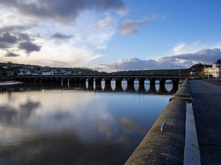 sunrise clouds reflecting in the River Torridge at Bideford`s ancient long bridge , Devon
