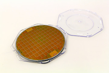 Silicon Wafers in plastic holder box on a table- A wafer is a thin slice of semiconductor material,...