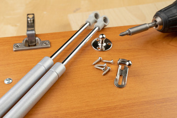 Gas lifter mounted in furniture cabinets. Small carpentry work in the workshop.