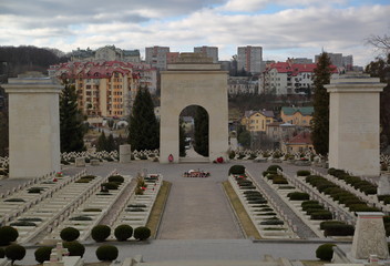Cmentarz Obrońców Lwowa / Orląt Lwowoskich, Lwów, Ukraina, panoaramiczny widok na groby polskich żołnierzy, łuk triumfalny, potęzne kolumny, nowoczesne budynki w tle © Wioletta