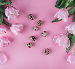 Easter eggs and pink tulips flowers on pink background. Happy Easter card. Top view, flat lay
