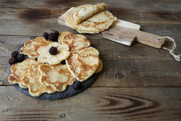 pancakes in the shape of a heart and flowers and pancakes on a board on a rustic wooden table