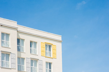 View to facade of building with windows with colored wooden shutters.
