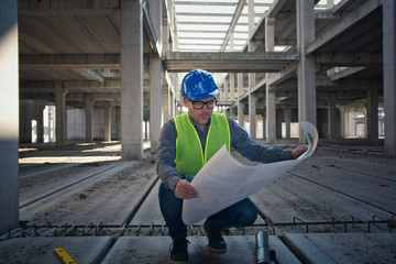 Architect analyzing building project on construction site