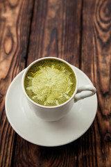 one cup of hot matcha green tea latte on wood background