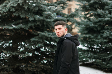 Hadsome young man in winter cloth standing in park