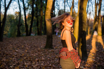 Street portrait of young beautiful woman wearing casual clothes. Model looking up. Female fashion concept. Emotions, people, beauty and lifestyle concept. Cute teenage girl with red sunglasses.