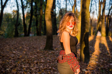 Street portrait of young beautiful woman wearing casual clothes. Model looking up. Female fashion concept. Emotions, people, beauty and lifestyle concept. Cute teenage girl with red sunglasses.