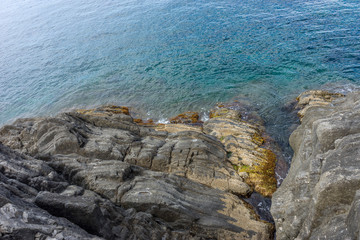 Italy,Cinque Terre,Riomaggiore, a close up of a rock next to a body of water