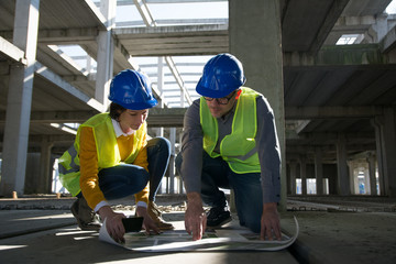 Two young architect going through construction plan details