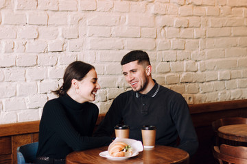 Flirting in a cafe. Beautiful loving couple sitting in cafe