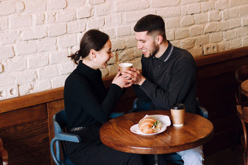 Flirting in a cafe. Beautiful loving couple sitting in cafe enjoying in coffe and conversation