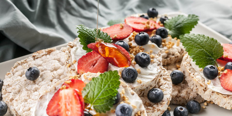 Food banner. Pouring honey on Puffed whole grain crispbread with curd cheese, mint leaves, fresh...
