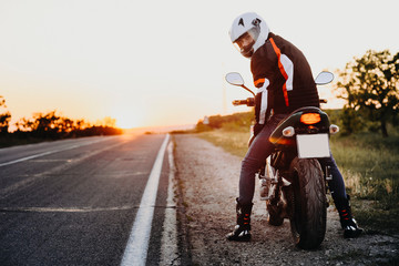 Full length portrait of a confident european biker preparing to his motorcycle trip around the...