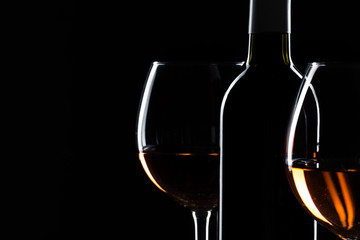  wine bottle and wine glass in a black background