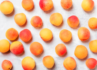 Fresh pink orange apricots on gray kitchen table background, top view