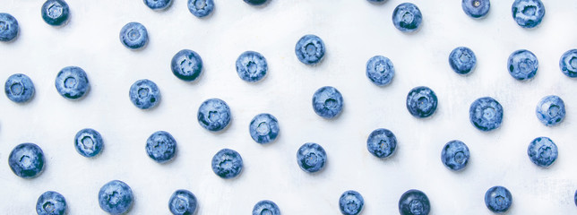 Food background with fresh blue blueberries on gray table, top view - obrazy, fototapety, plakaty