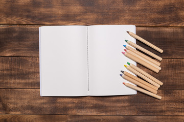 top view image of open notebook with blank pages next to cup of coffee on wooden table. ready for adding text or mockup.