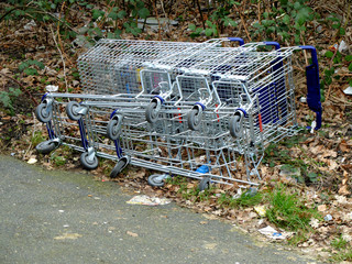Grocery carts fallen and laying on the ground. The concept of empty supermarkets, drop in sales, close up of supermarket branches because of the online shopping and e-commerce.