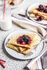 Pancakes with berries and honey on a gray background. Pancake week. Delicious breakfast of pancakes with jam.
