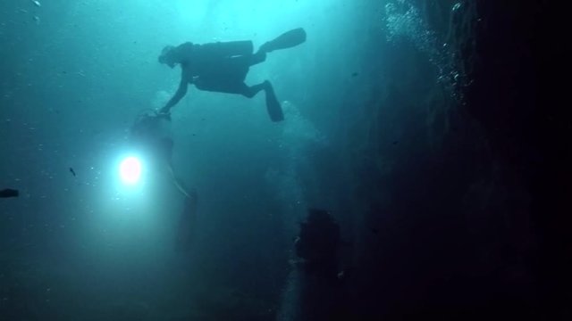 Scuba divers in the Zapotec or Hell's Bells cenote in Mexico.