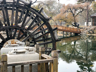 Water mill wheel in a calm little river and little pavilion on the background at The Imperial Summer Palace of The Mountain Resort in Chengde. China.  © Unwind