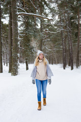 Fototapeta na wymiar young woman walking in winter forest