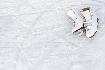 close up of figure skates and copy space over ice background with marks from skating