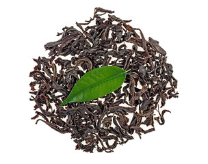 Black tea pile and green tea leaf on white background, top view.