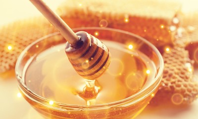 Honey and  wooden spoon  on background
