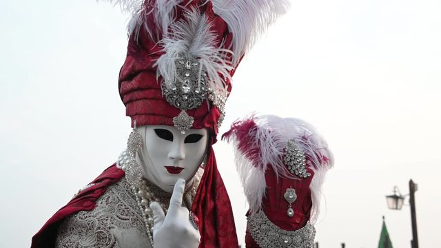 Venice - carnival masks are photographed with tourists in Piazza San Marco
