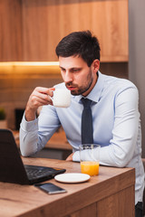 Young businessman working on laptop at home