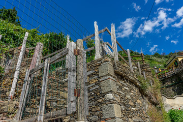 Italy, Cinque Terre, Vernazza, a close up of a hillside next to a wire fence